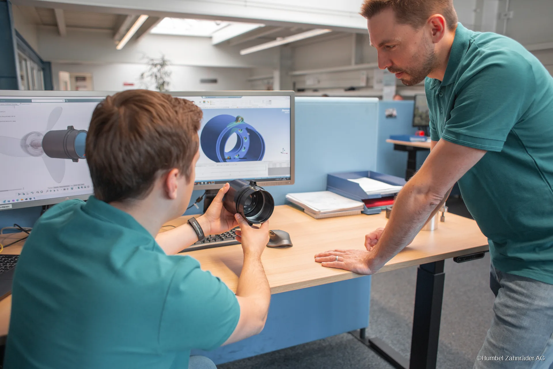 Two Humbel engineers review a component against its simulation model on screen